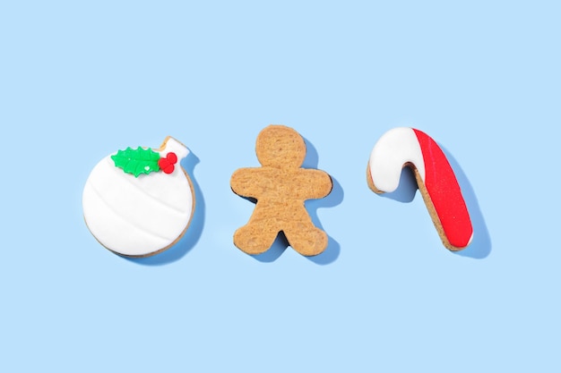 Foto galletas de jengibre navideñas con pasta de azúcar en la vista superior de fondo azul plana