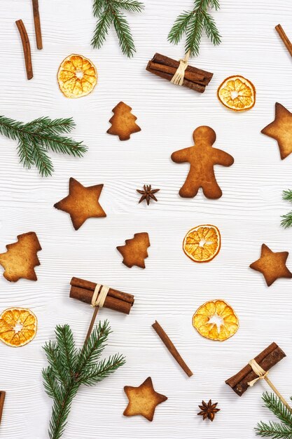 Galletas de jengibre navideñas, ramas de pino y palitos de canela