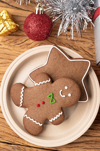 Galletas de jengibre navideñas tradicionales sobre una mesa de madera con decoración navideña de caja de regalo.