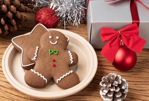 Galletas de jengibre navideñas tradicionales sobre una mesa de madera con decoración navideña de caja de regalo.