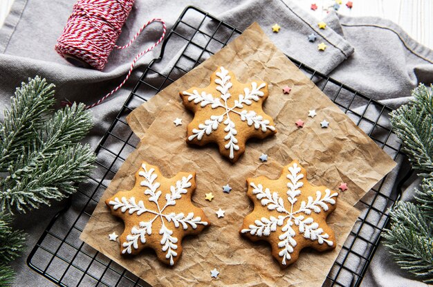 Galletas de jengibre en una rejilla para hornear de metal, decorando galletas navideñas