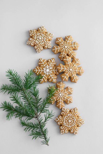 Galletas de jengibre tradicionales navideñas decoradas con glaseado de azúcar y una rama de abeto