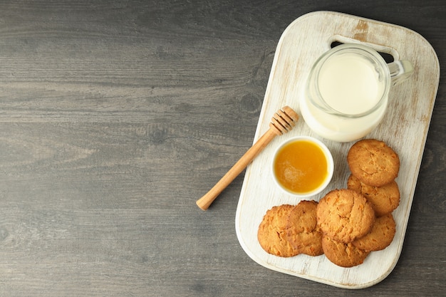 Galletas de leche, miel y calabaza en mesa de madera gris.