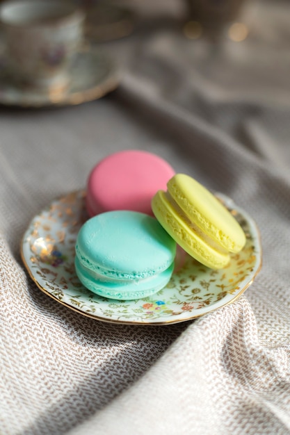 Foto galletas de macarons coloridos franceses tradicionales se colocan en la mesa de madera macarrones de colores pastel para una tarde ...