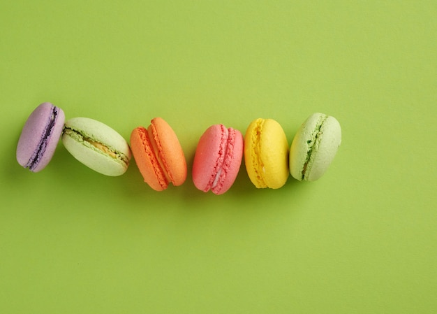 Galletas de macarons multicolores horneadas se encuentran en una fila