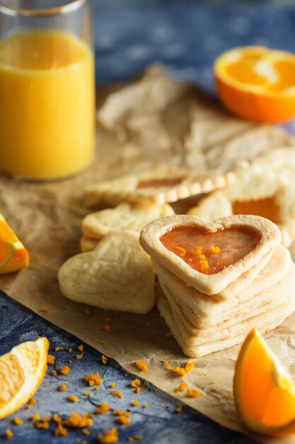 Galletas de mantequilla con glaseado de naranja en forma de corazones sobre azul