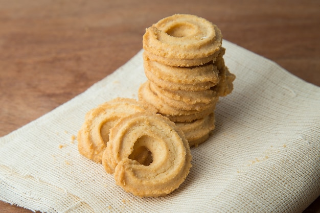 Galletas de mantequilla en el lino blanco en la tabla de madera.