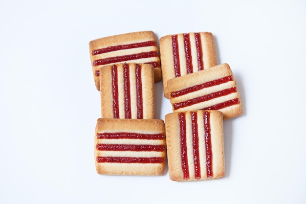 Foto galletas de mantequilla con mermelada sobre fondo blanco.