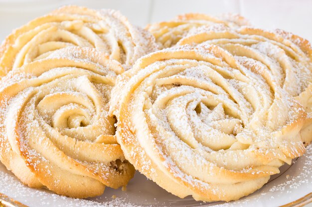 Galletas de mantequilla redondas rosas en forma de plato blanco. Fondo blanco. Copie el espacio. De cerca.