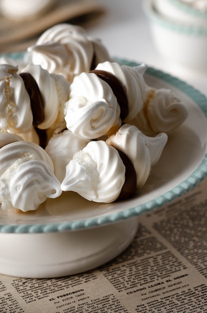 Galletas de merengue blanco con dulce de leche en un soporte para tartas