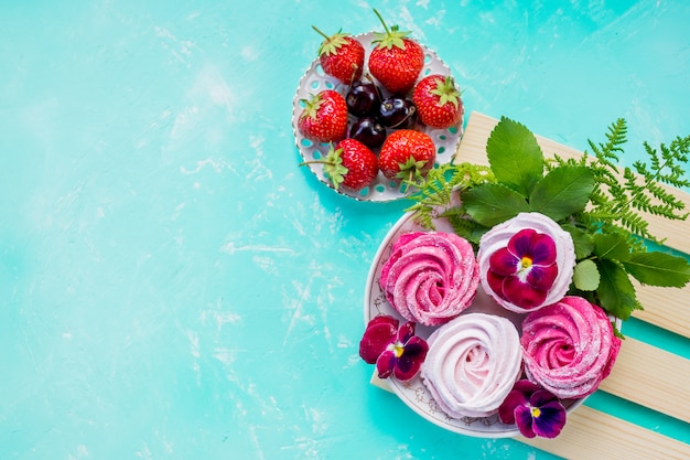 galletas de merengue rosa con bayas para el postre