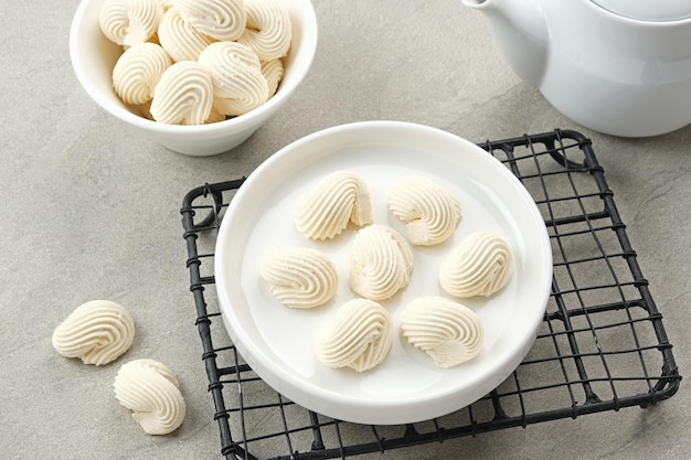 Galletas de merengue en tazón blanco hechas de harina batida con azúcar y huevos