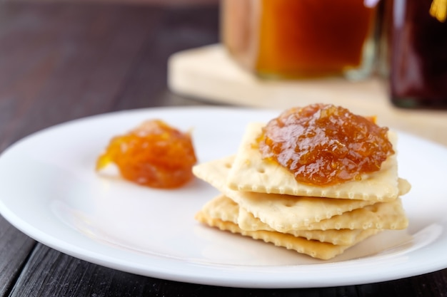 Foto galletas con mermelada de naranja sobre fondo de madera