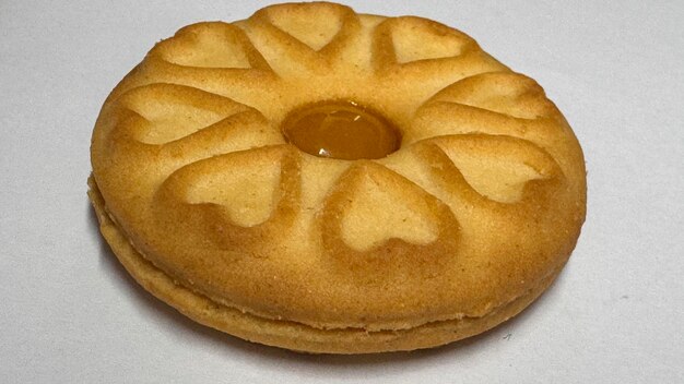 Galletas de mermelada de piña cuidadosamente dispuestas y fotografiadas sobre un fondo blanco sencillo