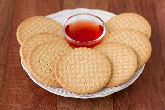 Galletas con mermelada en placa sobre fondo marrón