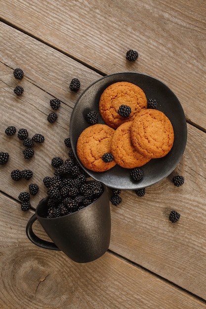 Foto galletas y moras sobre un fondo de madera