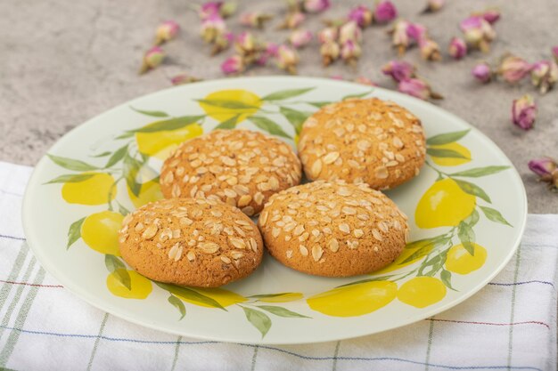 Galletas multicereales con capullos de rosa secos colocados sobre la mesa de piedra.