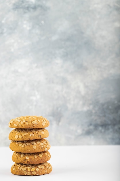 Foto galletas multigrano colocadas en la mesa blanca.