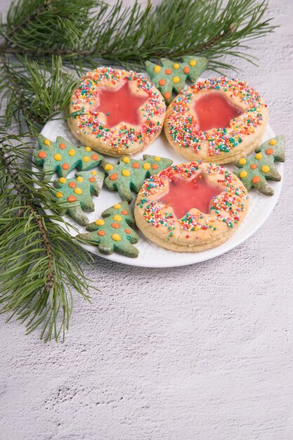 Foto galletas de navidad caseras sobre un fondo claro con ramas de pino espacio de copia de primer plano