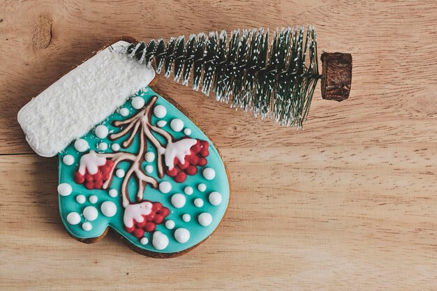 Las galletas de Navidad en forma de guante caprichosas con acentos nevados en un telón de fondo de madera rústica.