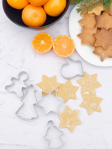 Galletas de Navidad con mandarinas sobre un fondo blanco.