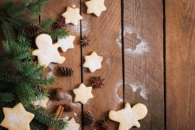 Galletas de navidad y oropel sobre una mesa de madera