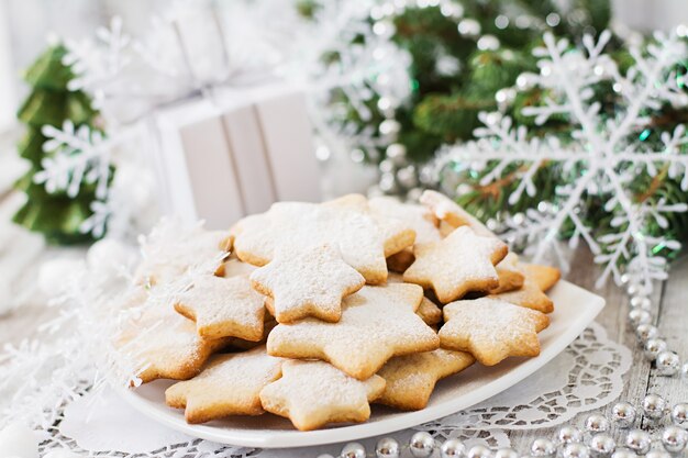 Galletas de navidad y oropel sobre una mesa de madera