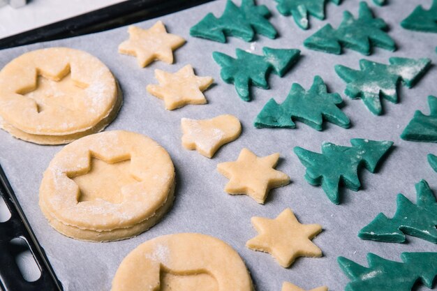 Foto galletas navideñas caseras antes de hornear en una bandeja para hornear closeup orientación horizontal