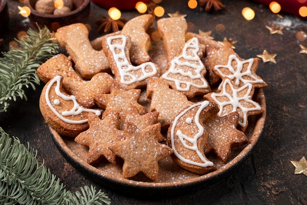 Galletas navideñas festivas decoradas con glaseado y azúcar en polvo en una placa de cerca