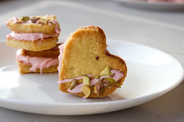 Galletas navideñas en forma de corazón, con crema de requesón y pistachos