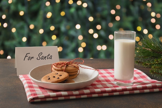 Galletas navideñas y leche para Santa cerca del árbol de Navidad