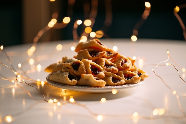 Galletas navideñas de mantequilla con mermelada de bayas decoradas con guirnaldas de luces cálidas