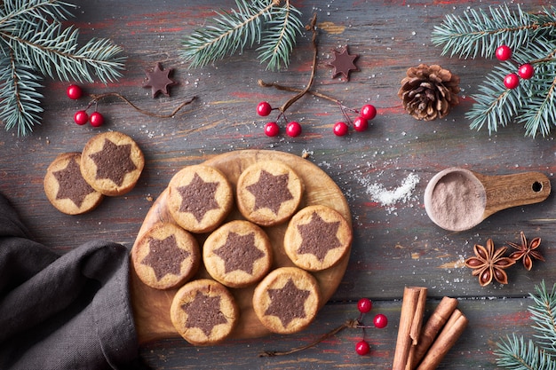 Galletas navideñas con patrón de estrella de chocolate con estrellas de chocolate, canela y ramas de abeto decoradas