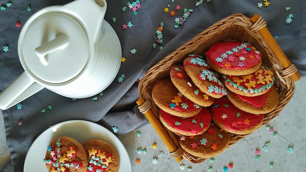 Galletas navideñas en una tetera basketa sobre un fondo claro con textiles grises