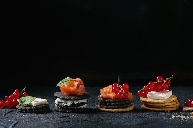 Galletas negras con salmón y bayas.