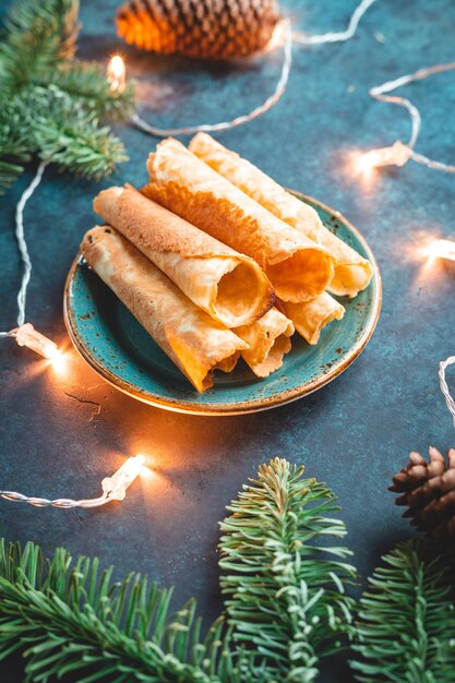 Galletas noruegas tradicionales de Navidad Krumkake entre la decoración de invierno