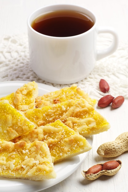 Galletas con nueces y taza de té en el cuadro blanco