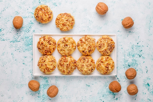 Galletas de nuez caseras en plato blanco con nueces, vista superior