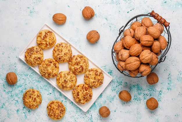 Galletas de nuez caseras en plato blanco con nueces, vista superior