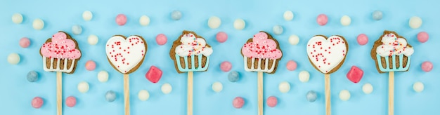 Galletas de pancarta en un palo y dulces sobre fondo azul Vista superior de dulces deliciosos y pastel de espacio de copia