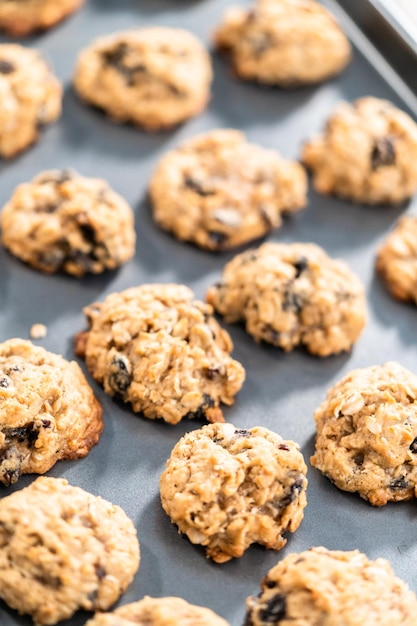 Galletas de pasas de avena masticables recién horneadas en una bandeja para hornear.