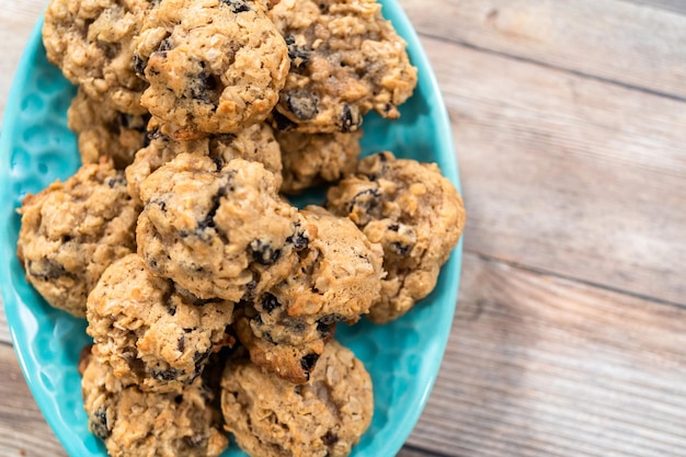 Galletas de pasas de avena masticables recién horneadas en un plato azul.