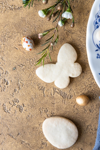 Foto galletas de pascua en un plato de cerámica con decoración floral y huevos en forma de caramelos