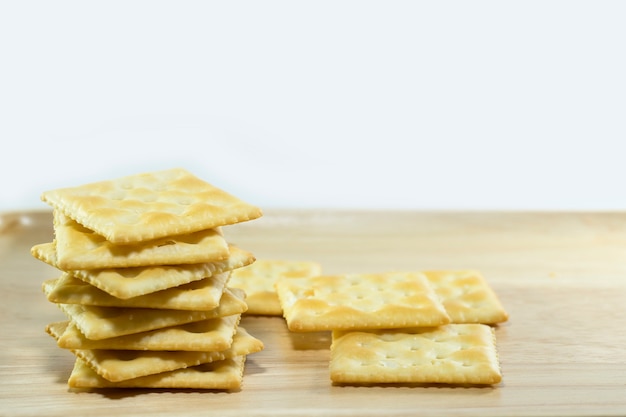 Galletas en plato de madera y fondo blanco.