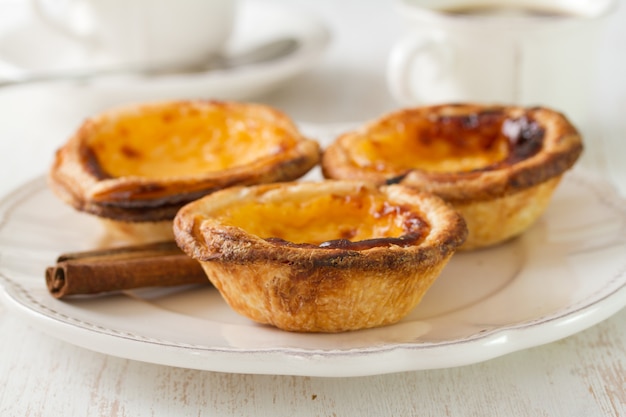 Galletas portuguesas con canela en plato blanco con taza de café