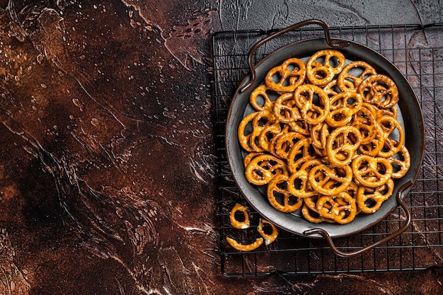 Galletas de pretzels salados pequeños con sal Fondo oscuro Vista superior Espacio de copia