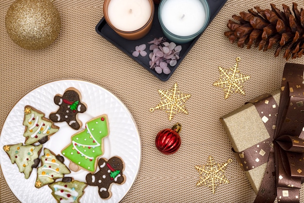 Galletas recubiertas de azúcar y galletas navideñas con velas aromáticas y adornos navideños.