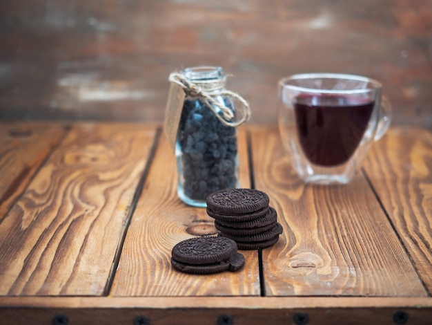 Galletas rellenas y compota de bayas en una taza de vidrio en una bandeja de madera