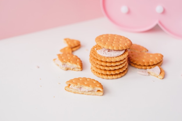 Galletas de relleno cremosas dulces sobre un fondo pastel rosa blanco