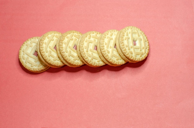 Galletas con relleno sobre fondo rosa